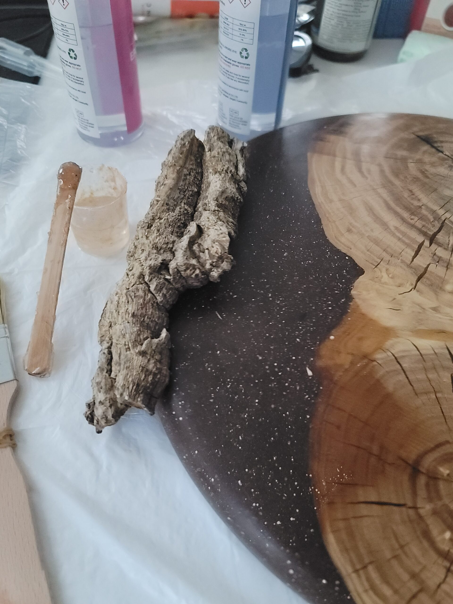 Using hot glue gun to stick the recycled tree bark on